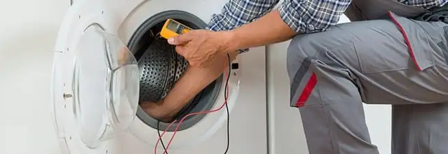 Dryer repair technician inspecting and repairing a clothes dryer in Omaha, NE