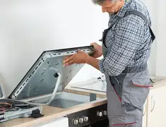 Appliance repair technician installing a built-in cooktop in Omaha, NE