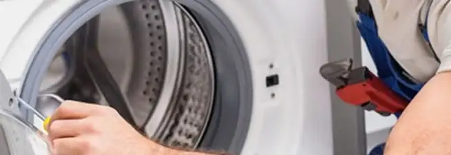 Appliance technician repairing a clothes dryer drum and internal parts in Omaha, NE