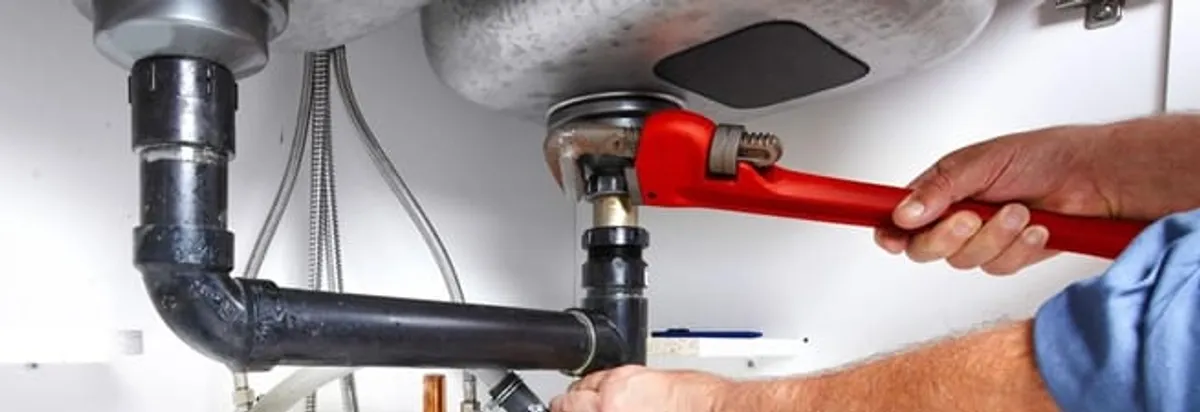 Garbage disposal repair technician tightening the sink drain and disposal connection in Omaha, NE