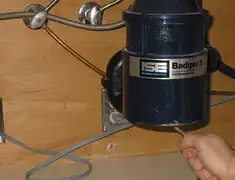 Garbage disposal repair technician tightening the mounting ring under a sink in Omaha, NE