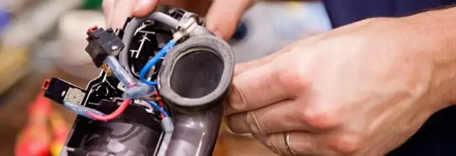 Vacuum repair technician reconnecting wiring and components in Omaha, NE