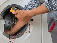 Washing machine repair technician testing a front-load washer with diagnostic tools in Omaha, NE
