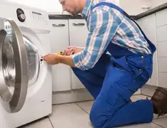 Washing machine repair technician servicing a front-load washer in Omaha, NE