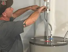 Water heater repair technician tightening supply line connections in Omaha, NE