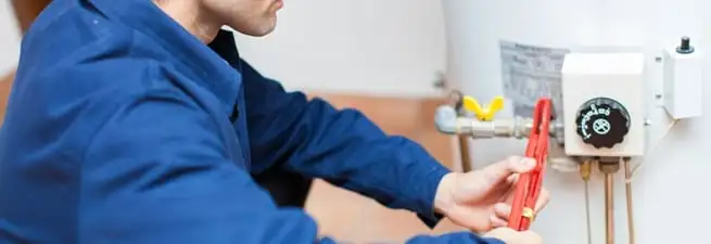 Water heater repair technician adjusting the temperature control and gas valve in Omaha, NE